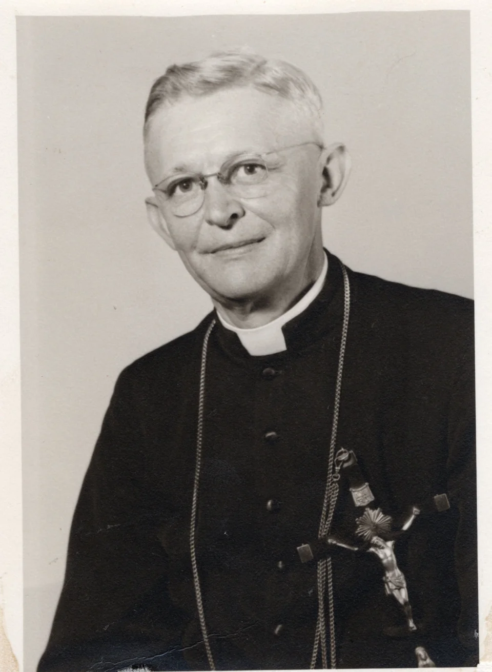 Portrait of Father George John Niekamp wearing a clerical collar and crucifix