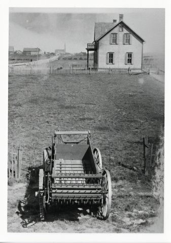 Photo caption - Alfrida (Kleinhenz) Willke writes in 1977: Maria Stein, O. in the late 1890s. House in picture belonged to John M. Kramer, now the Ed Garmam residence. House next in line is Leo Streacker’s. The picture of manure spreader was taken before the “spreader part” was invented. In 1899 spreader factory was started in Maria Stein, O. In 1910 factory moved to Coldwater, O. Now Avco New Idea Farm Equipment.